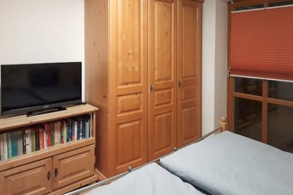 Schlafzimmer mit Balkon und Fernseher 